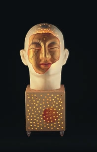 Photograph of a gold-toned head and patterned rectangular light sculpture