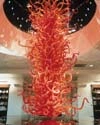 Photograph of a tall orange glass installation in a museum interior